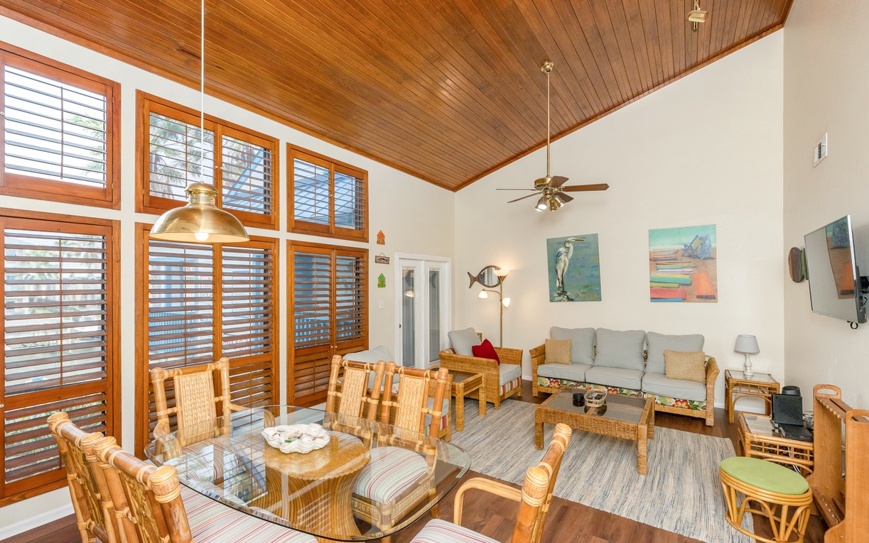 Relax in your airy living space with stunning wood ceilings, tropical artwork, and abundant natural light streaming through louvered windows.