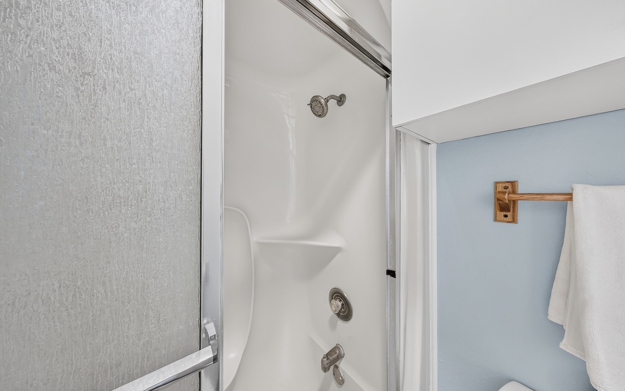Your private bathroom features a clean tub-shower combo with modern fixtures and soft towels ready for your arrival.