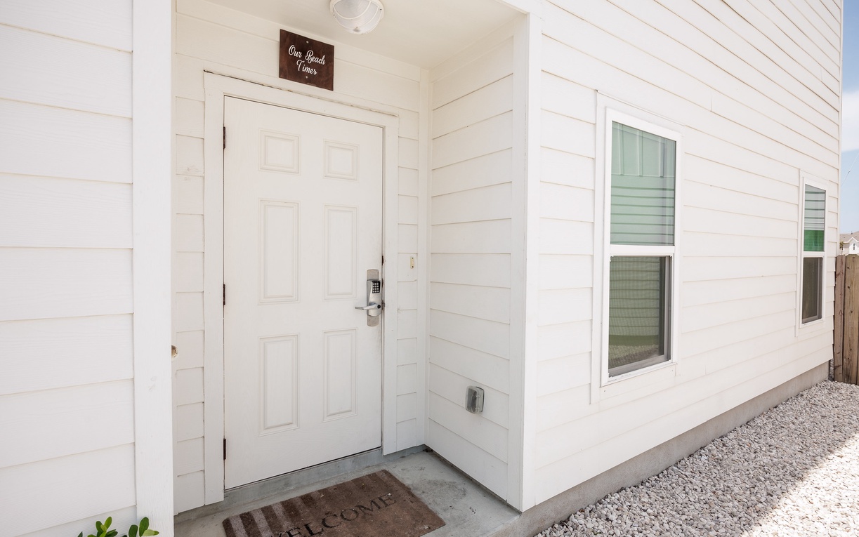 Crisp white siding and a welcoming entrance mat create your peaceful arrival to this charming coastal retreat.