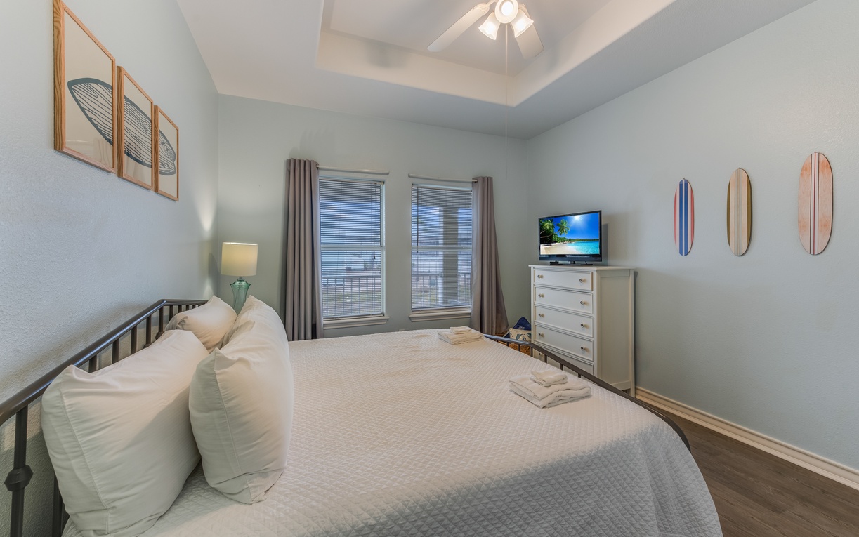Your peaceful bedroom retreat features coastal charm with soft linens, beach-themed art, and plenty of natural light.