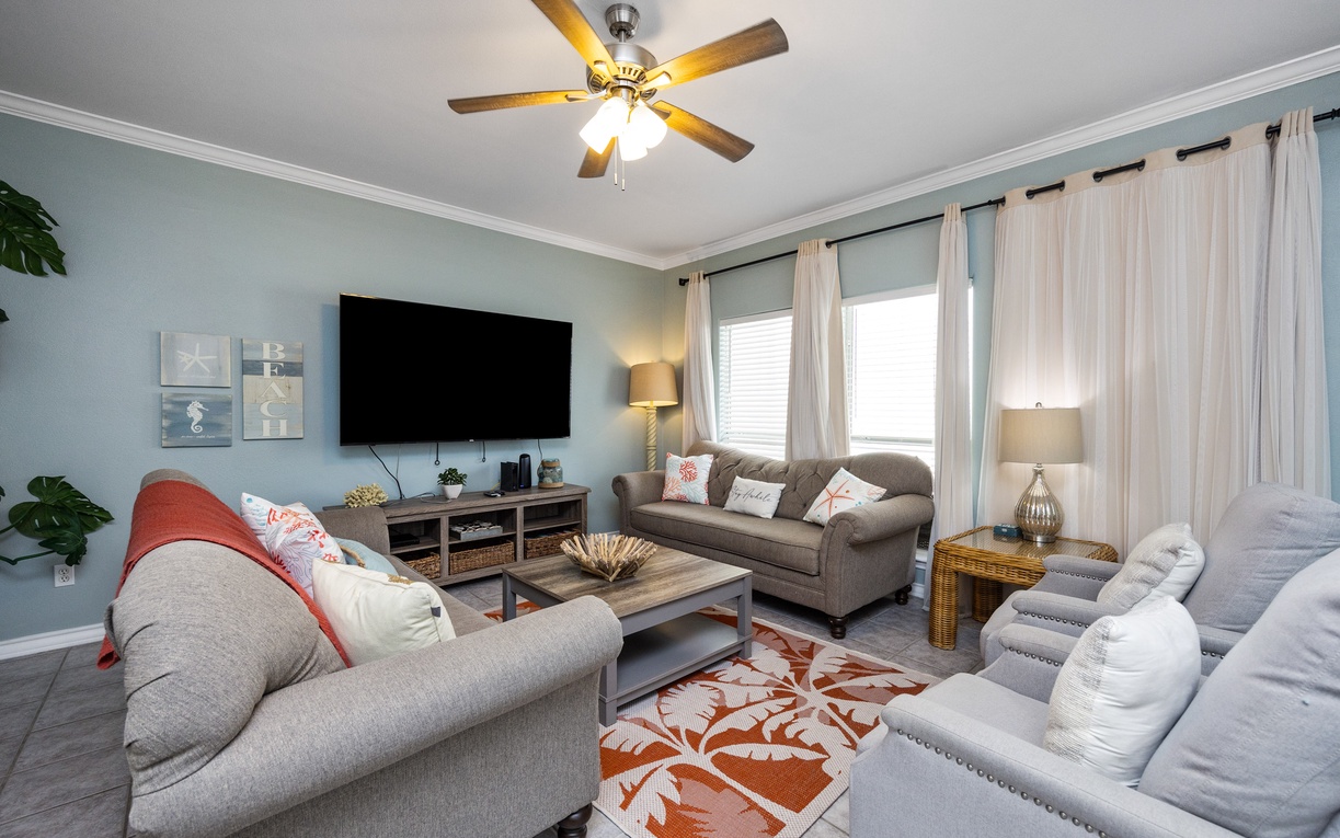 Sink into plush sofas with soft pillows while your favorite shows play on the large TV, all cooled by the ceiling fan overhead.