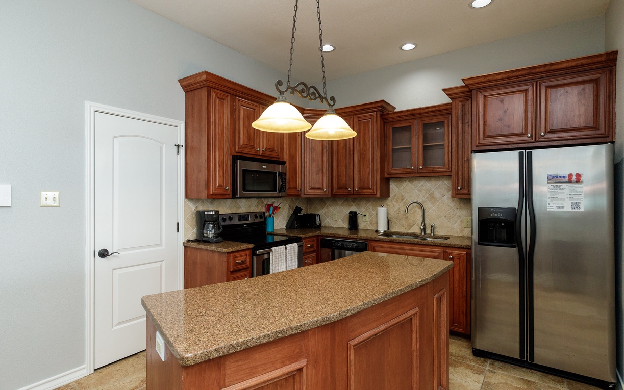 Your fully-equipped kitchen features rich wood cabinets, granite counters, and stainless appliances—perfect for creating memorable meals during your stay.