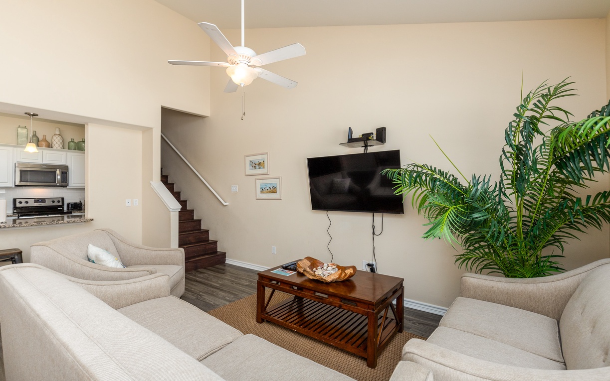 Relax in your bright living room with plush seating, ceiling fan, and TV for cozy evenings in.