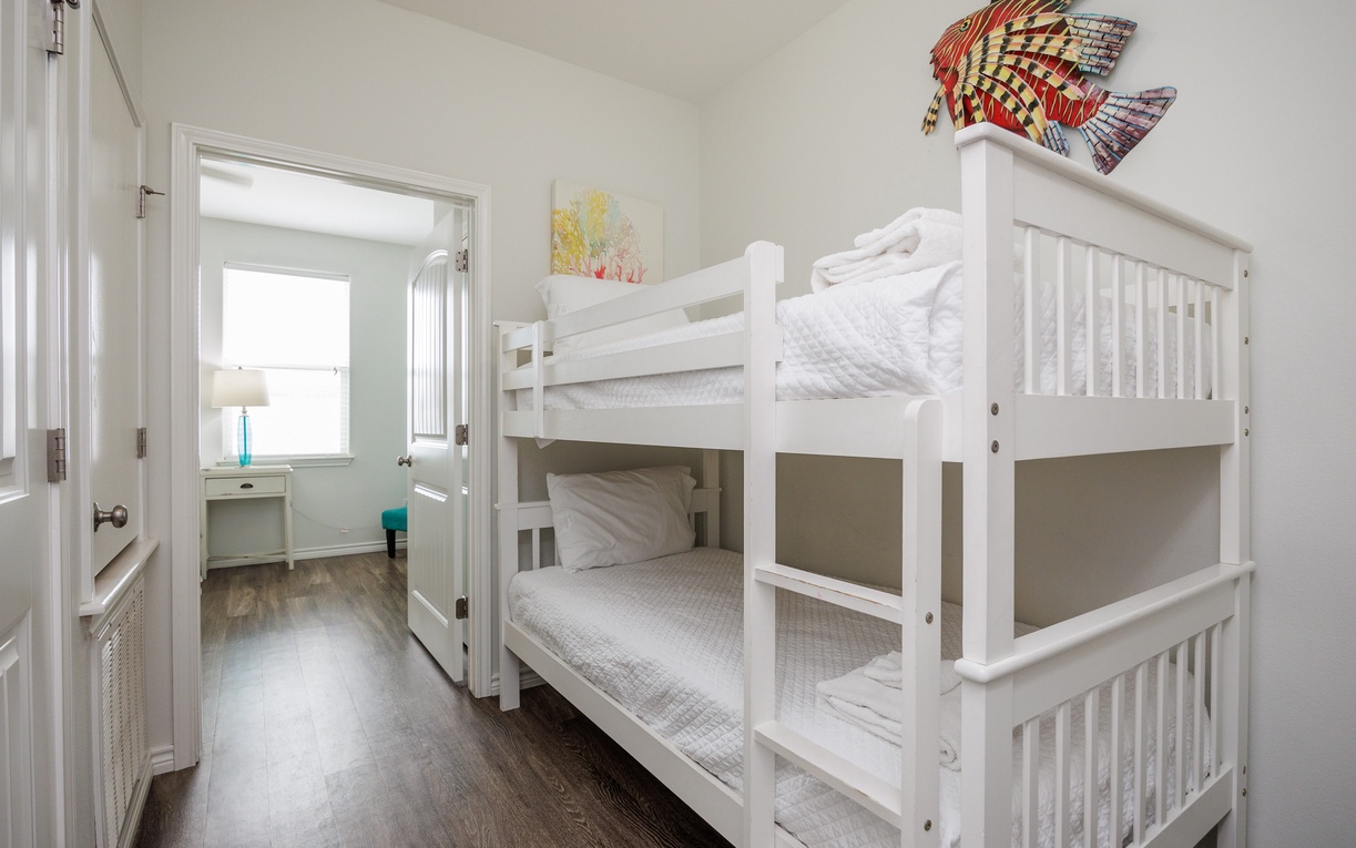 Your kids will love this cheerful bunk room, complete with colorful wall art and crisp white linens for a cozy sleep.