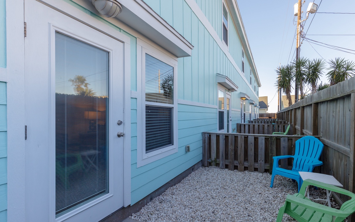 Step out onto your private patio with cheerful seating, where gravel underfoot and tropical palms create your perfect outdoor retreat.