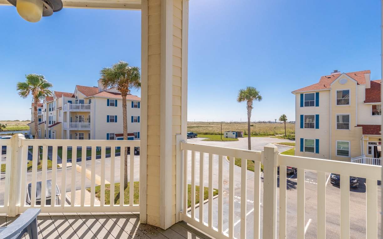 Step onto your private balcony and soak in the coastal charm with tropical palms and colorful buildings creating the perfect backdrop for morning coffee.