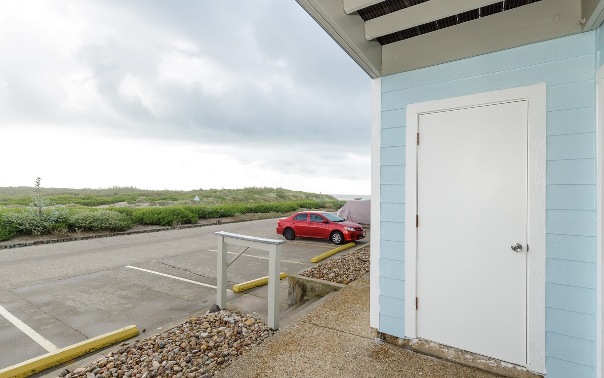 Covered entrance with convenient parking and scenic coastal views beyond the property grounds.
