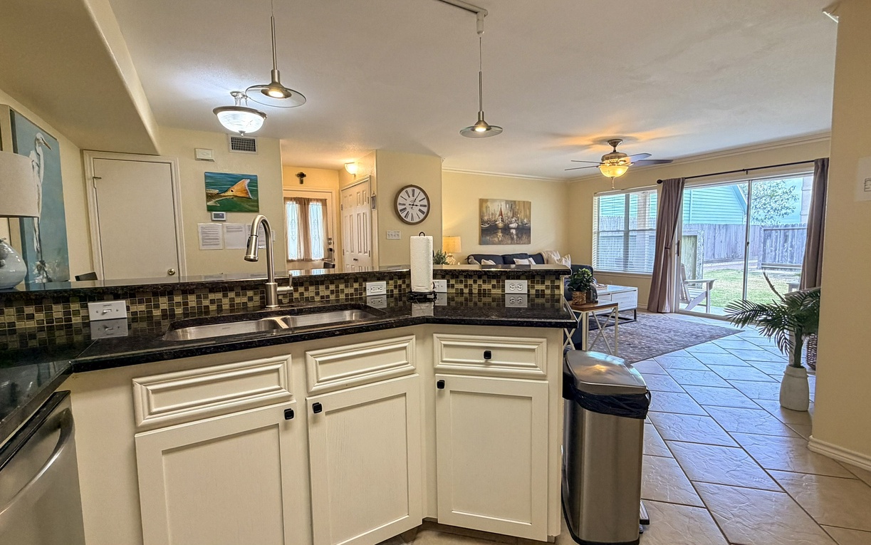 Step into your spacious kitchen featuring granite countertops and mosaic tile backsplash, perfectly connected to the bright living area where you'll relax.