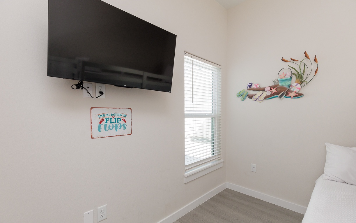 Kick back in your cozy bedroom with beach-themed decor and a wall-mounted TV for your favorite shows.