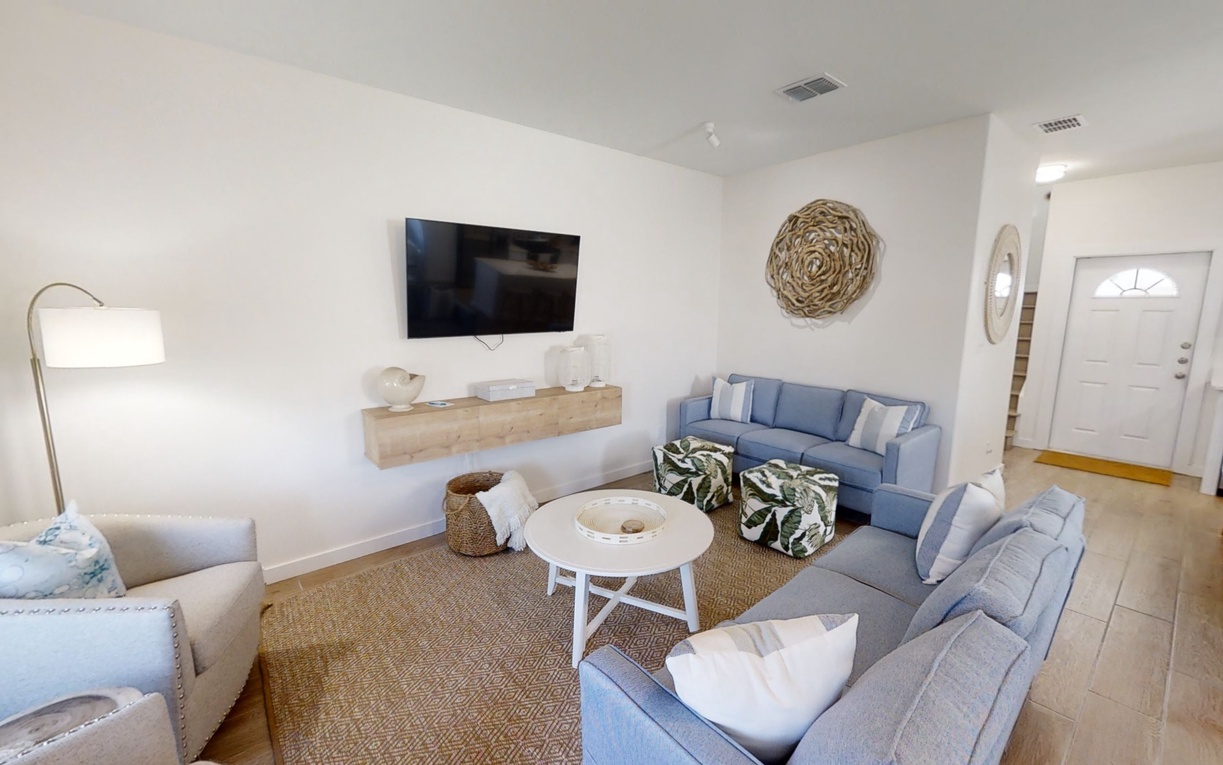 Sink into plush sectional seating where natural textures and coastal blues create your perfect retreat for movie nights and relaxation.