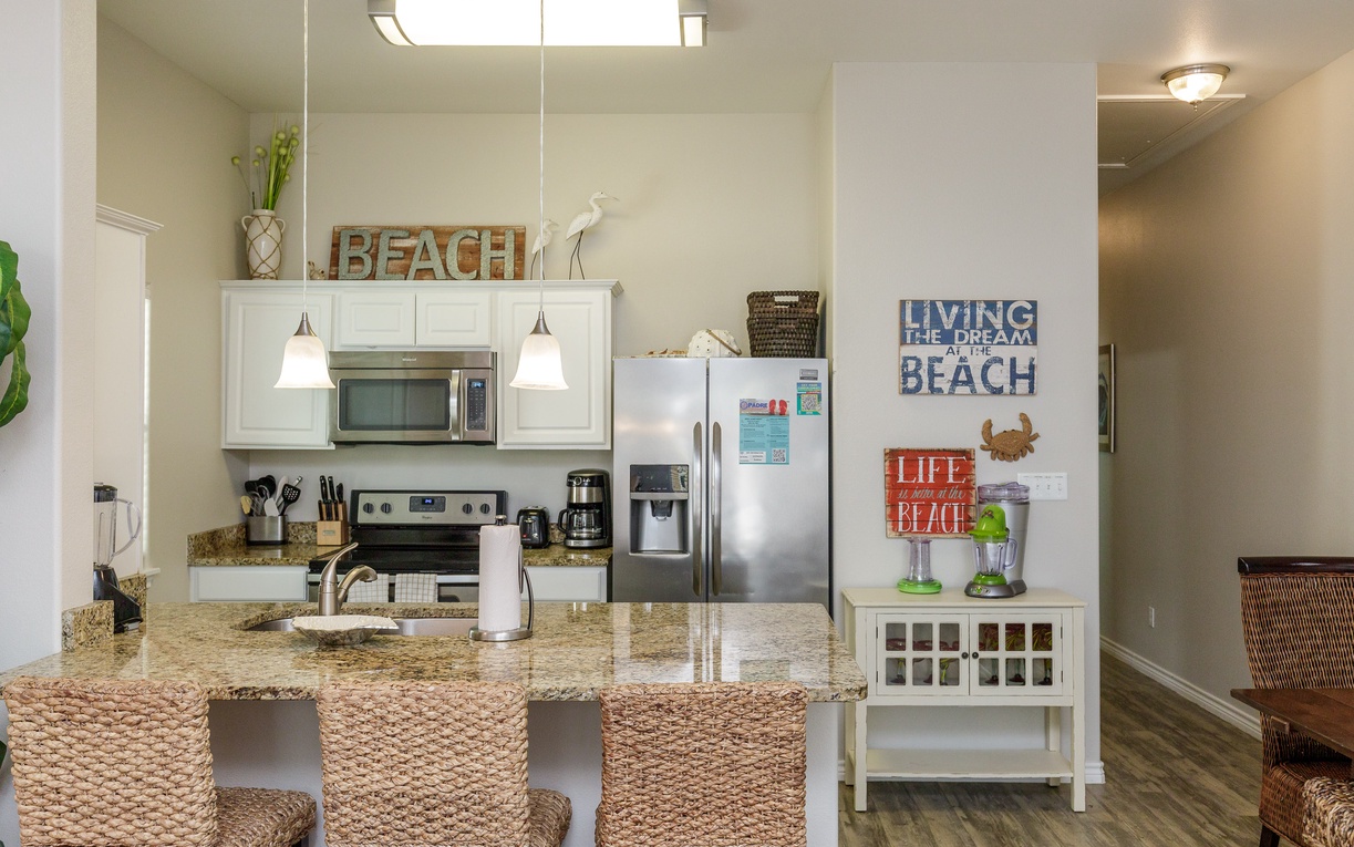 Your fully equipped kitchen awaits with granite counters, stainless appliances, and charming beach-themed touches that set the perfect coastal vacation mood.