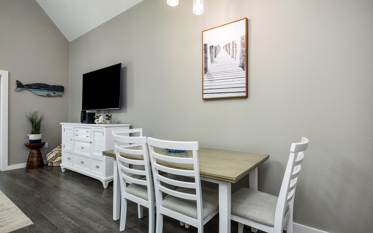 Your bright dining space features coastal charm with a spacious table for meals and a flatscreen TV for entertainment during downtime.