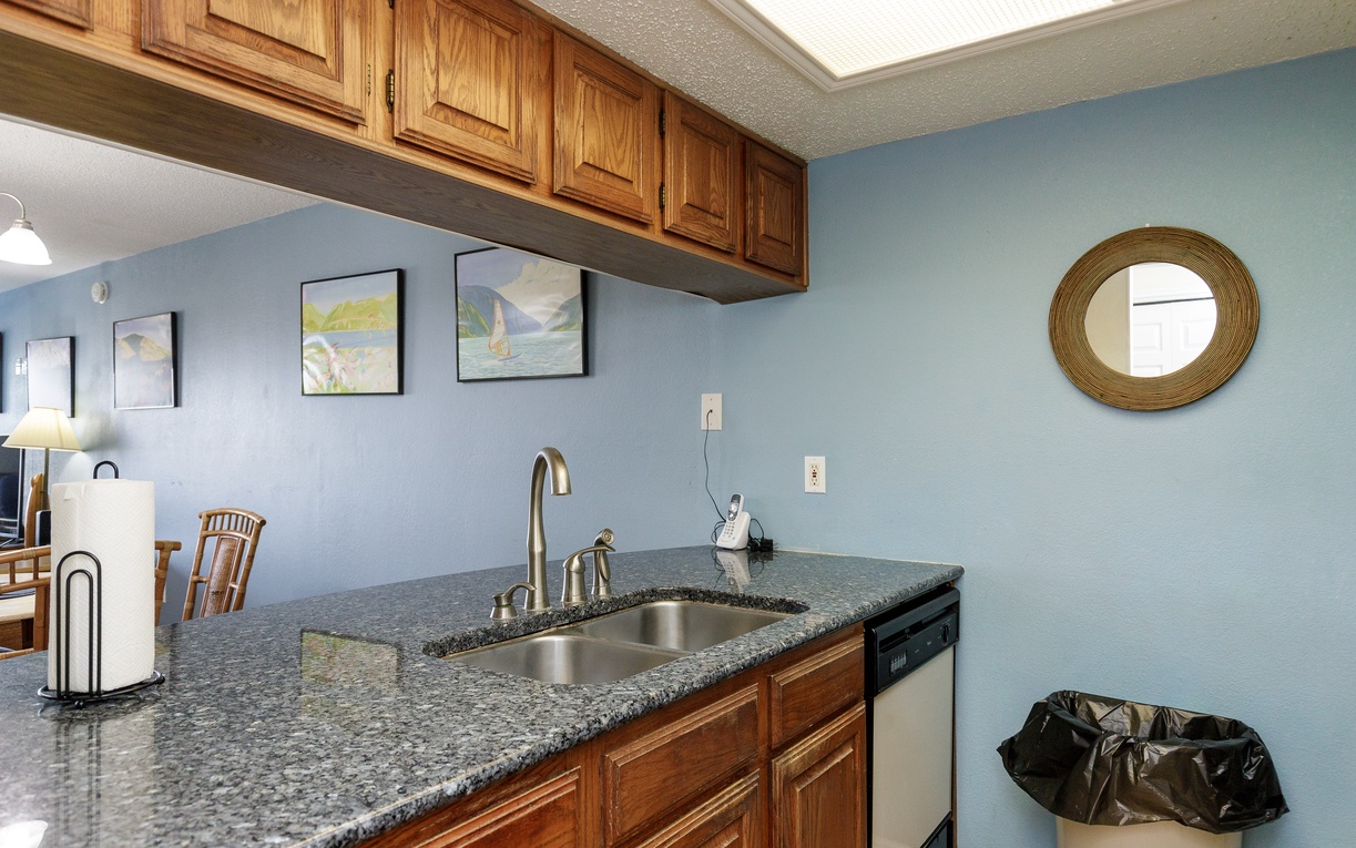 Your well-appointed kitchen features granite countertops and warm wood cabinetry, creating the perfect space for preparing meals during your stay.