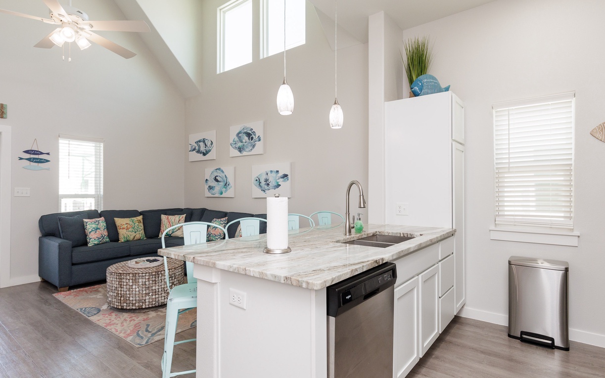 Step into your bright open-concept space where the kitchen island becomes your morning coffee spot and the cozy living area awaits relaxing evenings.