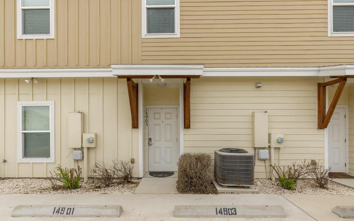 Modern townhome exterior with welcoming covered entrance and landscaped front area.