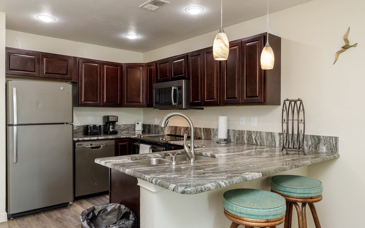 Your fully equipped kitchen features granite counters, stainless appliances, and a convenient breakfast bar for morning coffee.