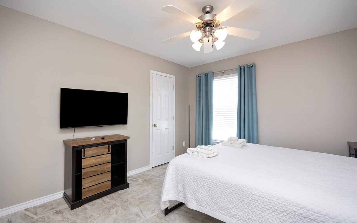 Unwind in your peaceful bedroom with plush bedding, entertainment center, and soothing natural light.