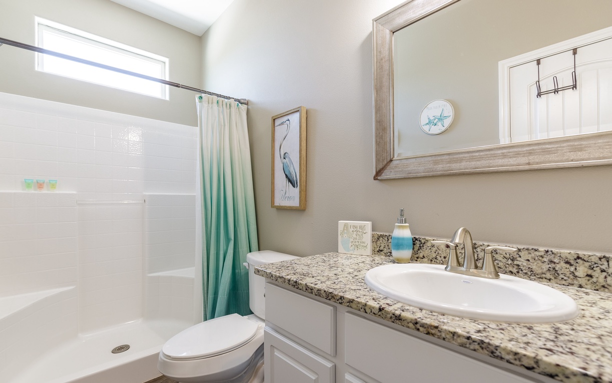 Step into your serene bathroom with granite counters, spacious shower, and coastal touches that make your daily routine feel like a spa retreat.