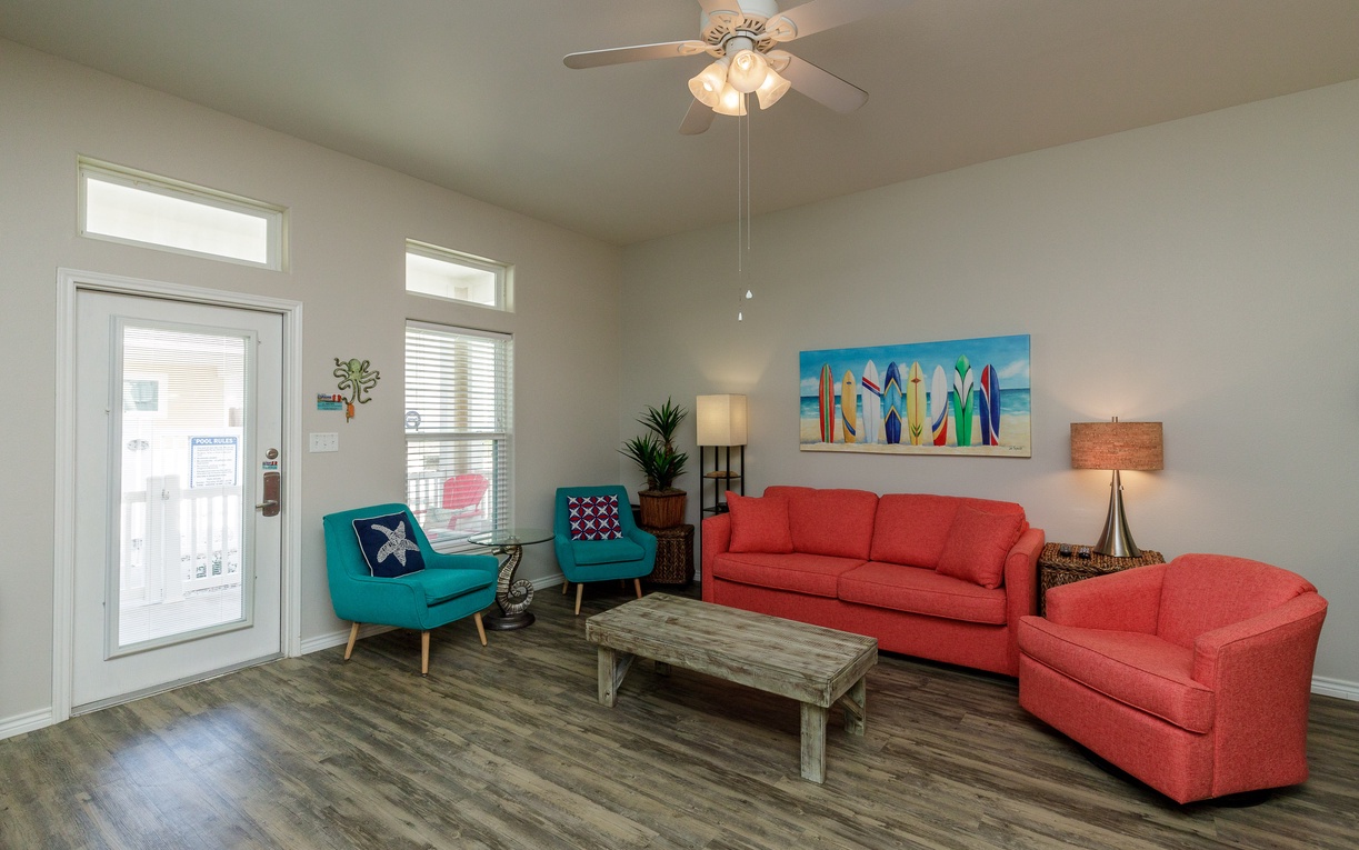 Unwind in your vibrant living space with coral sofas, turquoise accents, and coastal artwork that creates the perfect beach house atmosphere.