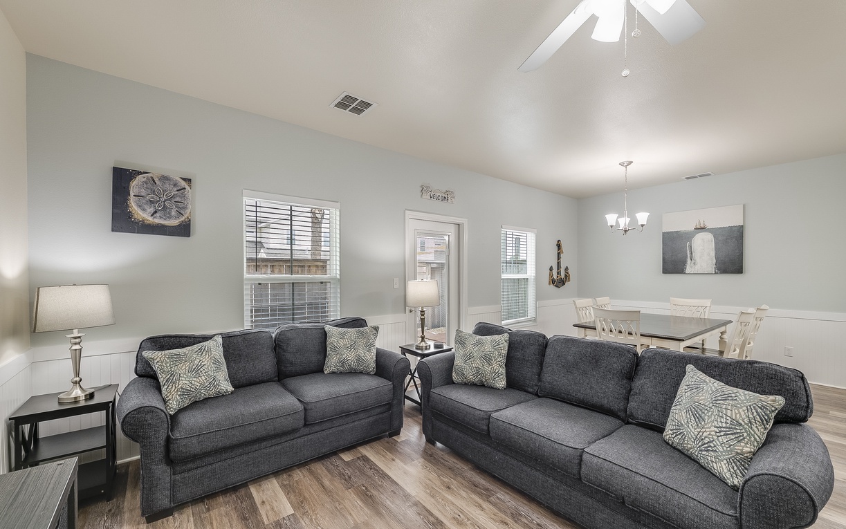 Sink into plush gray sofas in your bright, open living space where comfortable seating and natural light create the perfect retreat.