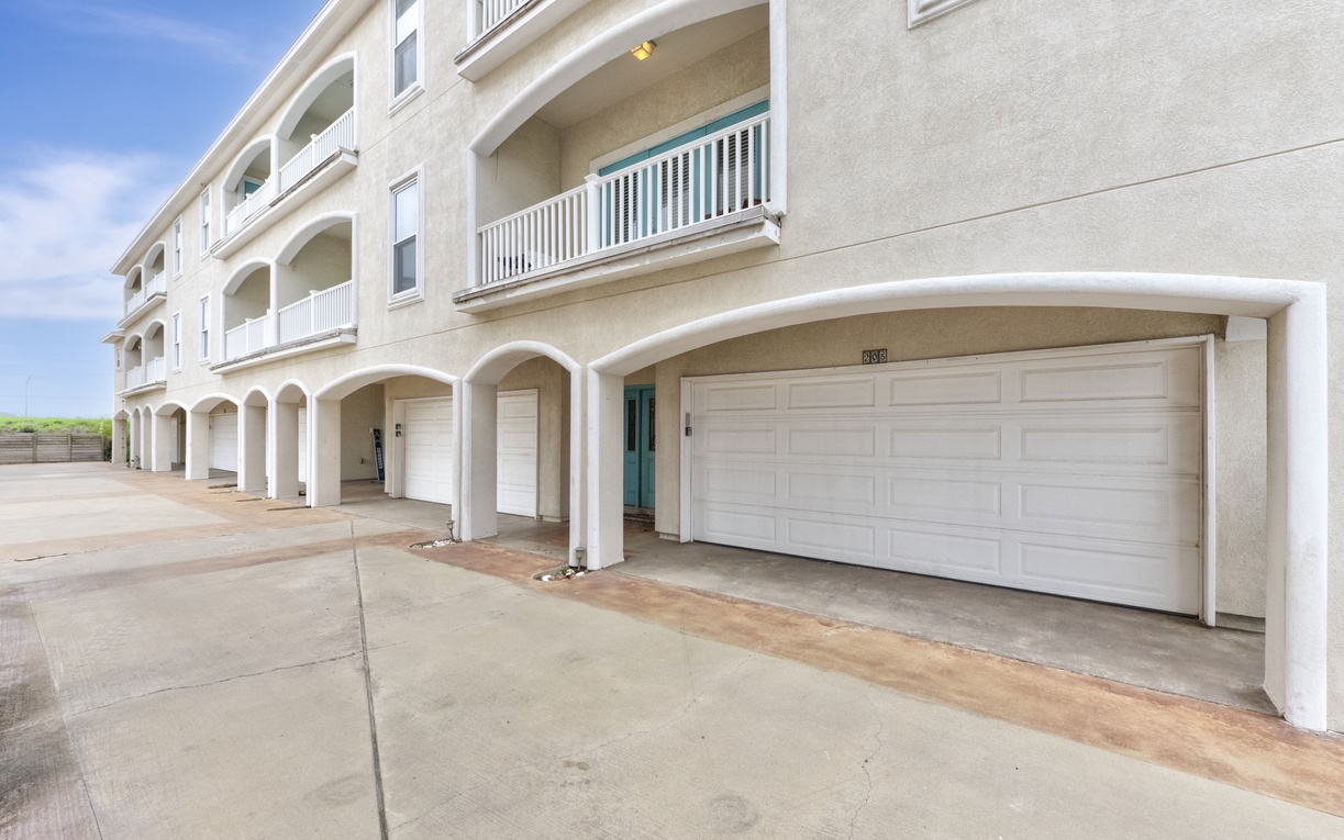 Elegant beachside building with covered parking and private balconies in a peaceful coastal setting.
