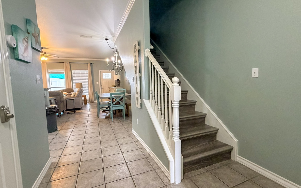Step into your welcoming home with warm lighting and coastal blues flowing through open living spaces.