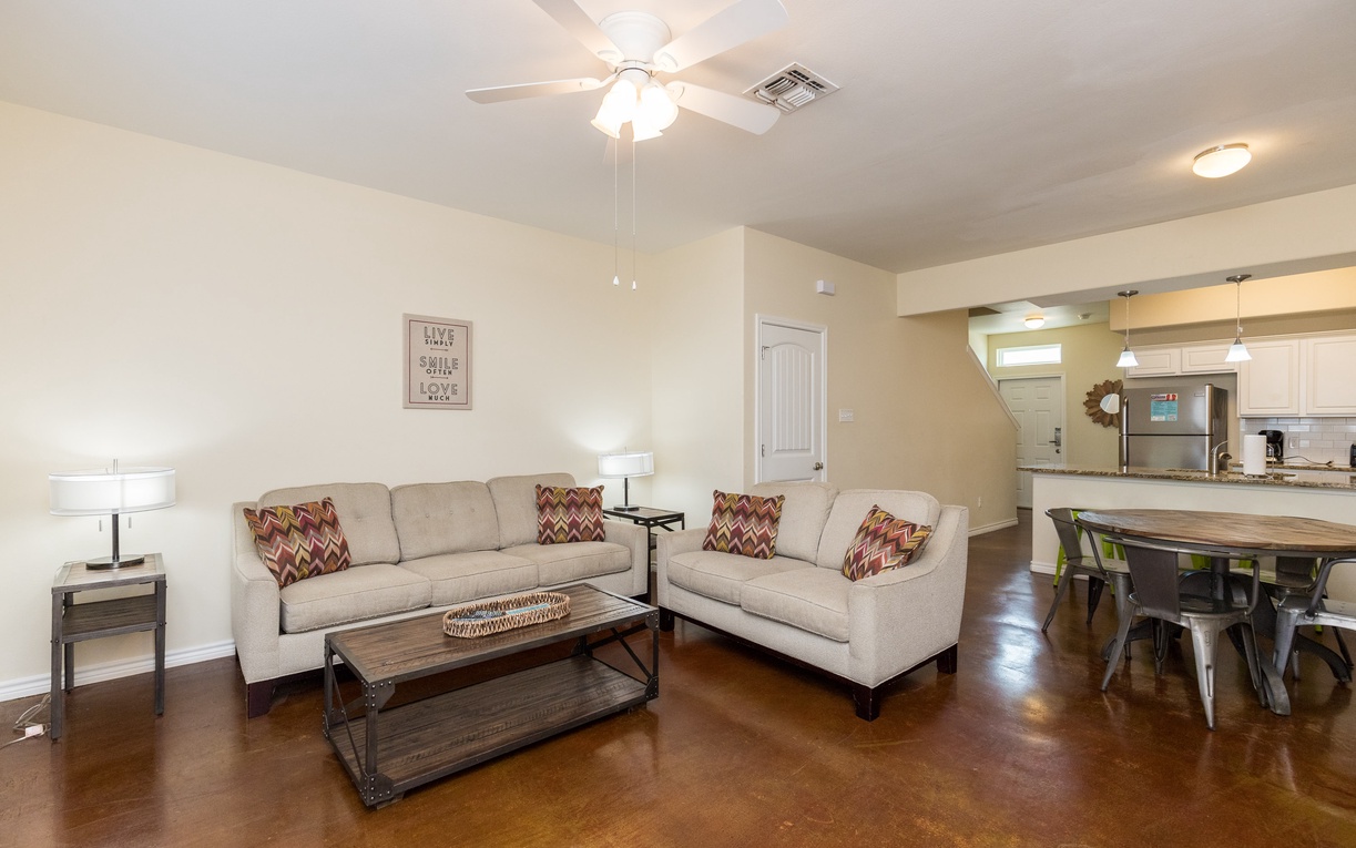 Unwind in your spacious open-plan living area with plush seating, gleaming polished floors, and modern touches throughout.