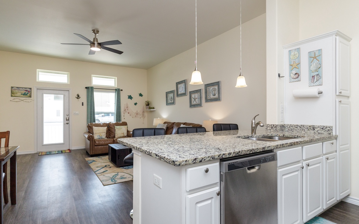 Your open-concept kitchen flows seamlessly into the living area, where granite countertops and modern appliances create the perfect space for cooking.