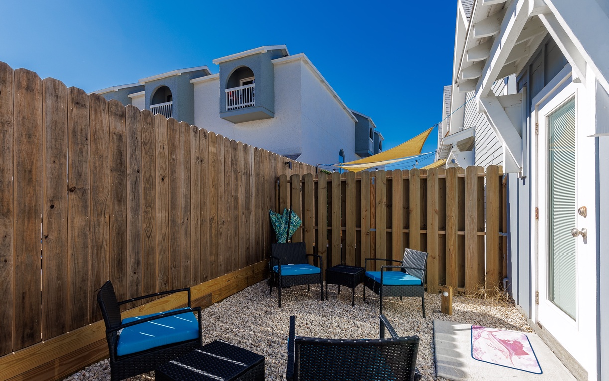 Your private patio offers comfortable seating with vibrant blue cushions, perfect for morning coffee or evening relaxation under the open sky.