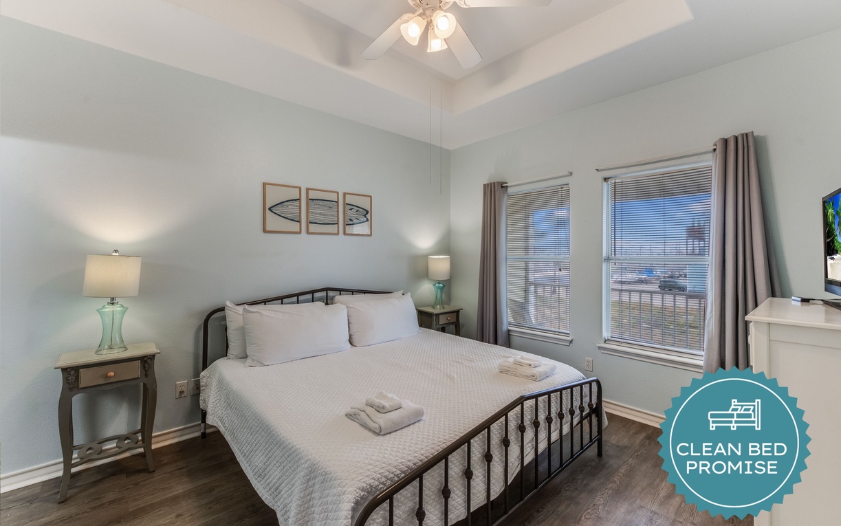 Unwind in your serene bedroom with crisp linens, coastal artwork, and gentle ceiling fan breezes creating the perfect retreat.