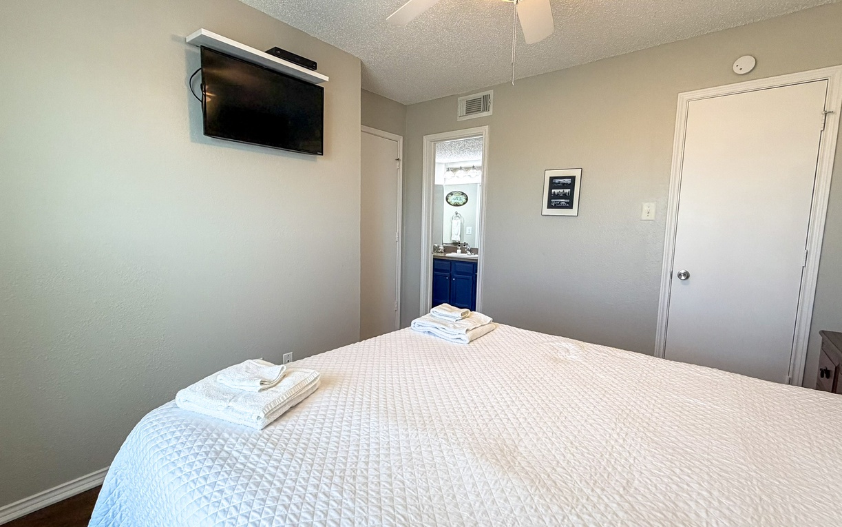 Relax in your comfortable bedroom with fresh linens, wall-mounted TV, and ensuite bathroom access for ultimate convenience.