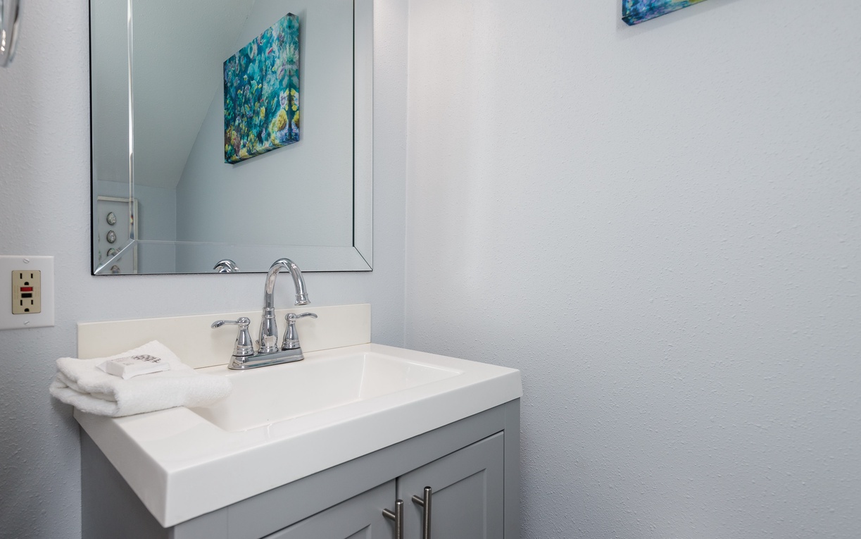 Convenient first-floor half bathroom with a bright vanity and modern coastal touches.