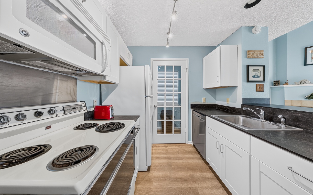 Everything you need for convenient vacation dining! This bright kitchen offers essential appliances, ample cabinet storage, and plenty of counter space for preparing everything from quick breakfasts to home-cooked dinners.