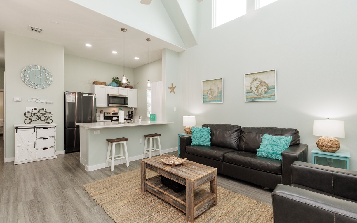 Your bright, open-concept retreat blends comfort with coastal charm. Relax on the cozy sofa while natural light pours through the skylight above.