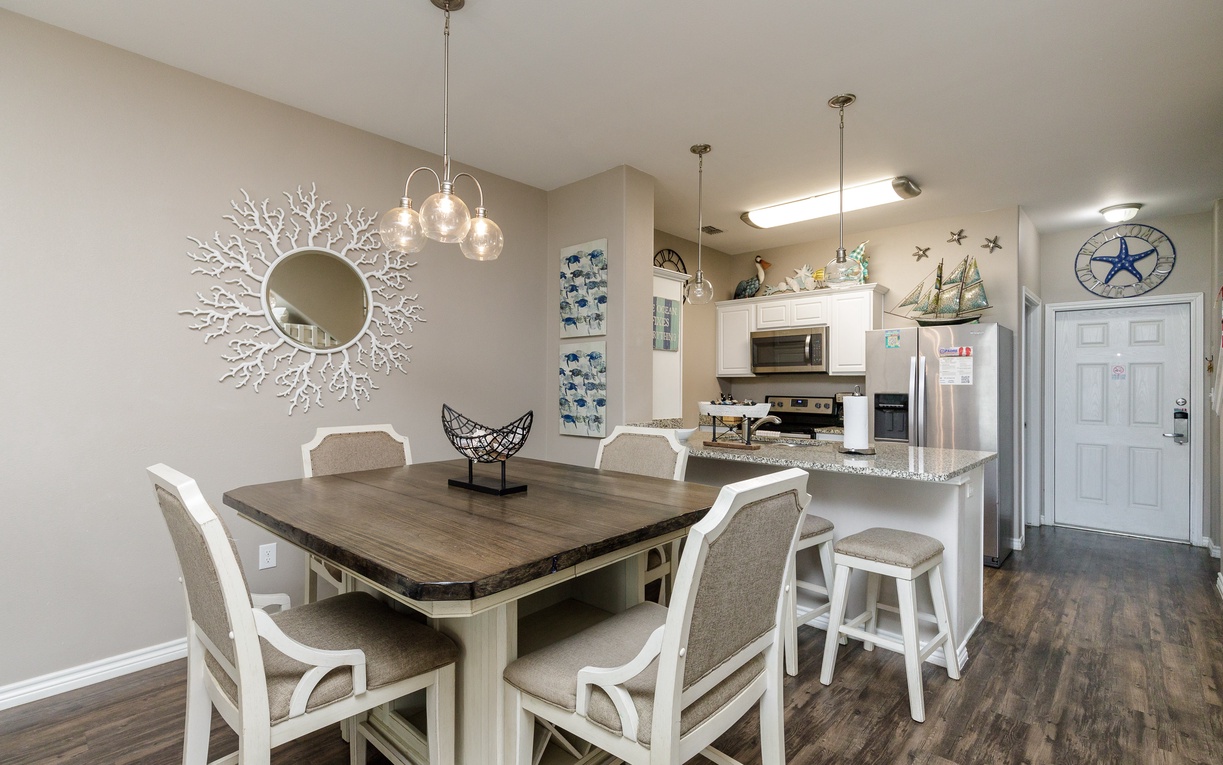 Gather around your spacious dining table for memorable meals, with a fully equipped kitchen featuring modern appliances and coastal charm throughout.