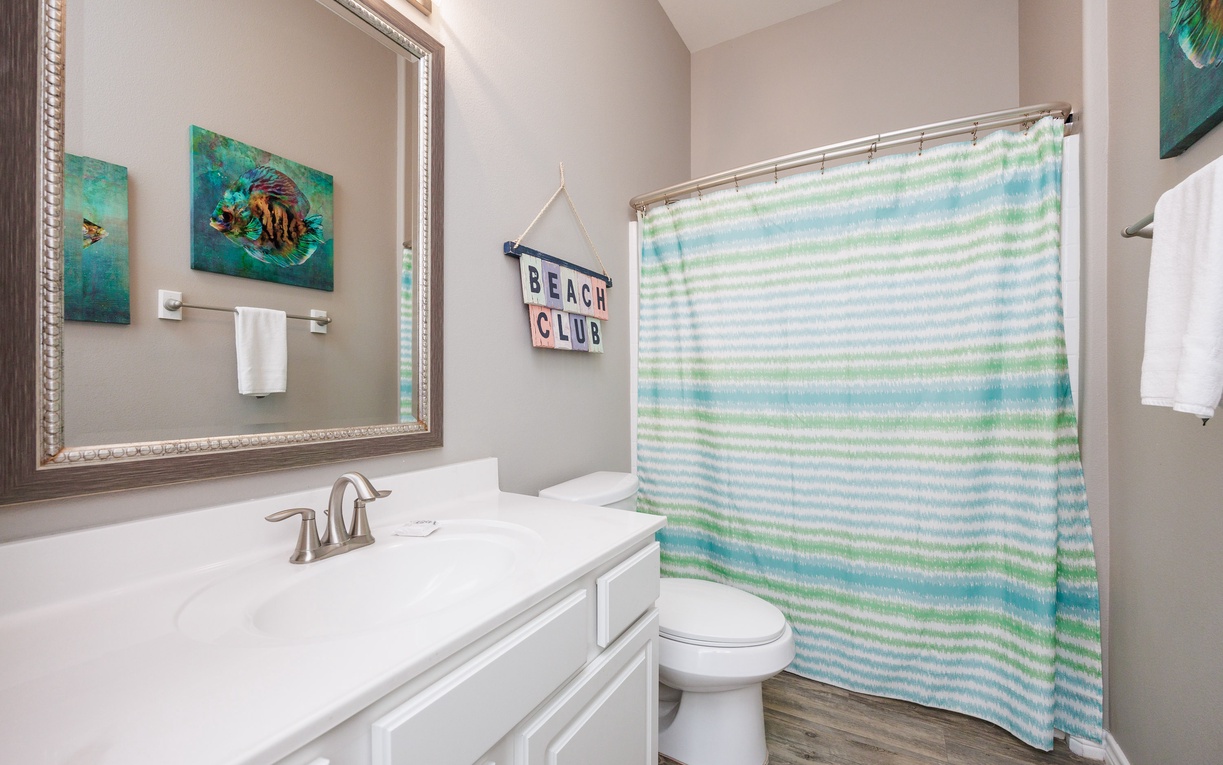 Refresh in your private beach-themed bathroom with coastal artwork and ocean-inspired décor creating a serene spa-like atmosphere.