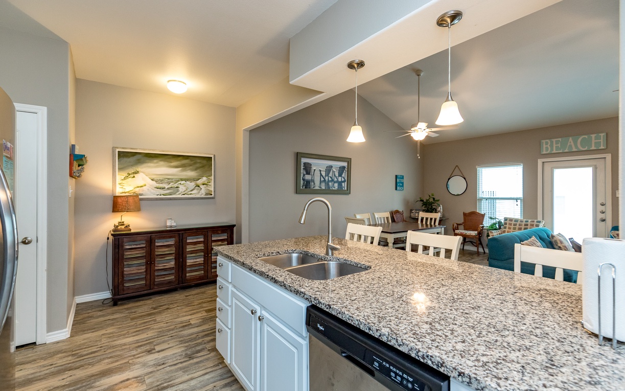 Cook with style in your open kitchen featuring granite counters, stainless steel appliances, and a breakfast bar overlooking the cozy living area.
