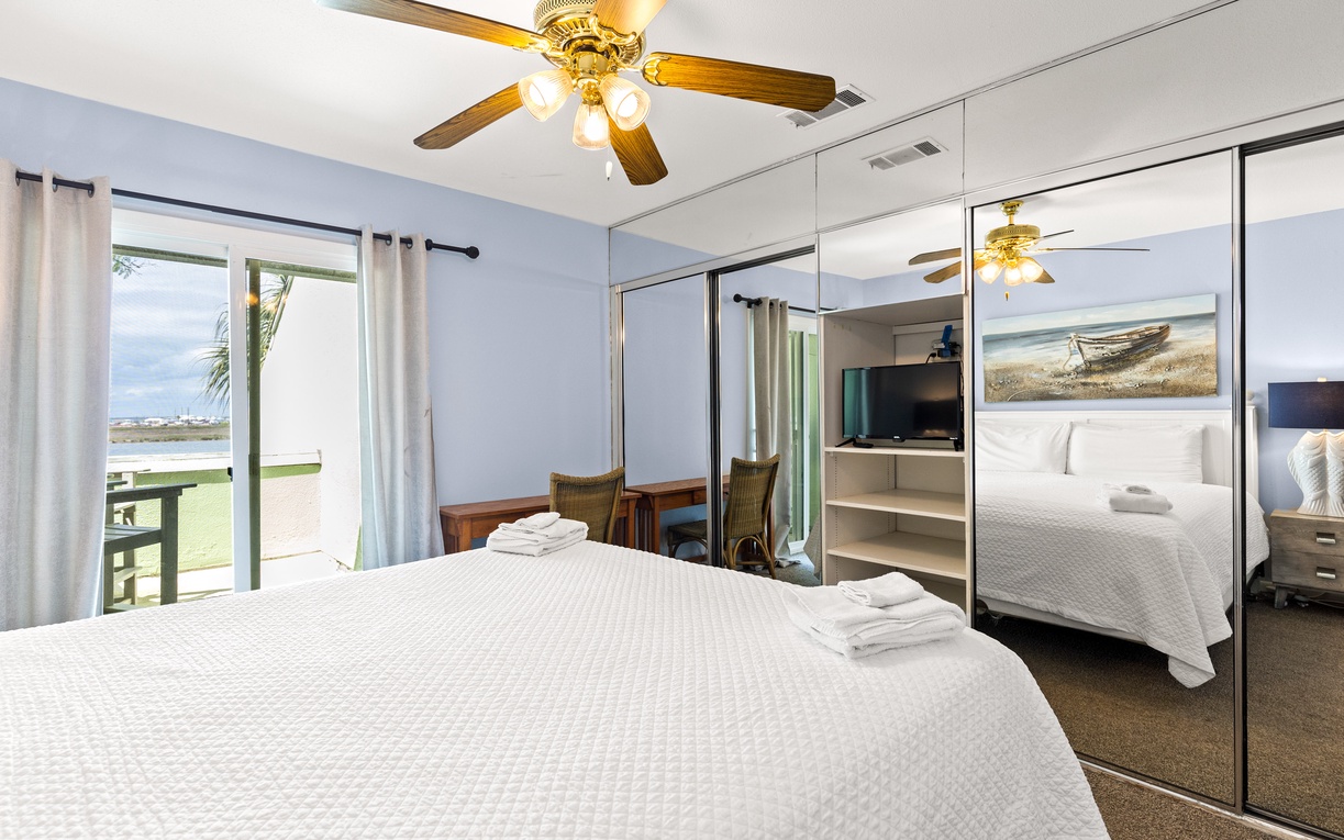 Rest peacefully in your coastal bedroom with soft linens, mirrored closets, and ceiling fan comfort.
