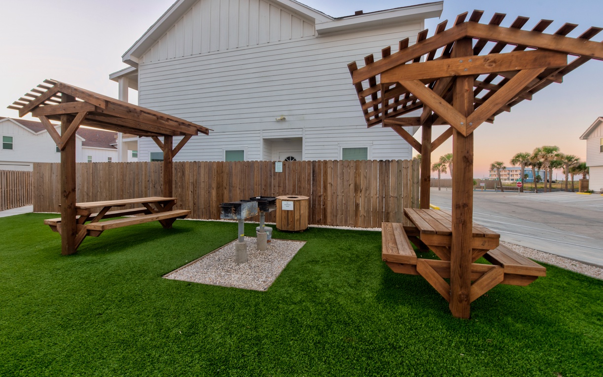 Relax under the wooden pergolas with picnic tables and BBQ grill - perfect for outdoor dining and enjoying coastal evenings together.