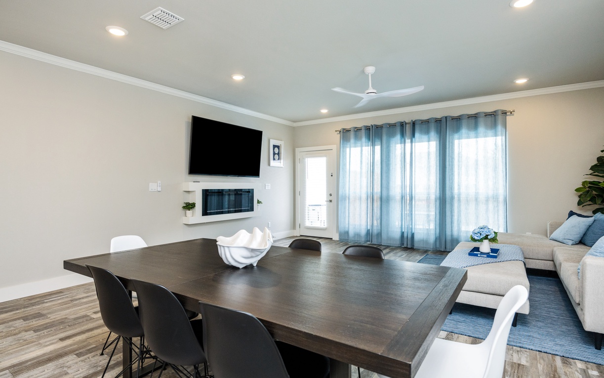 Gather around this sleek dining table while enjoying your favorite shows on the wall-mounted TV, creating perfect moments for shared meals.