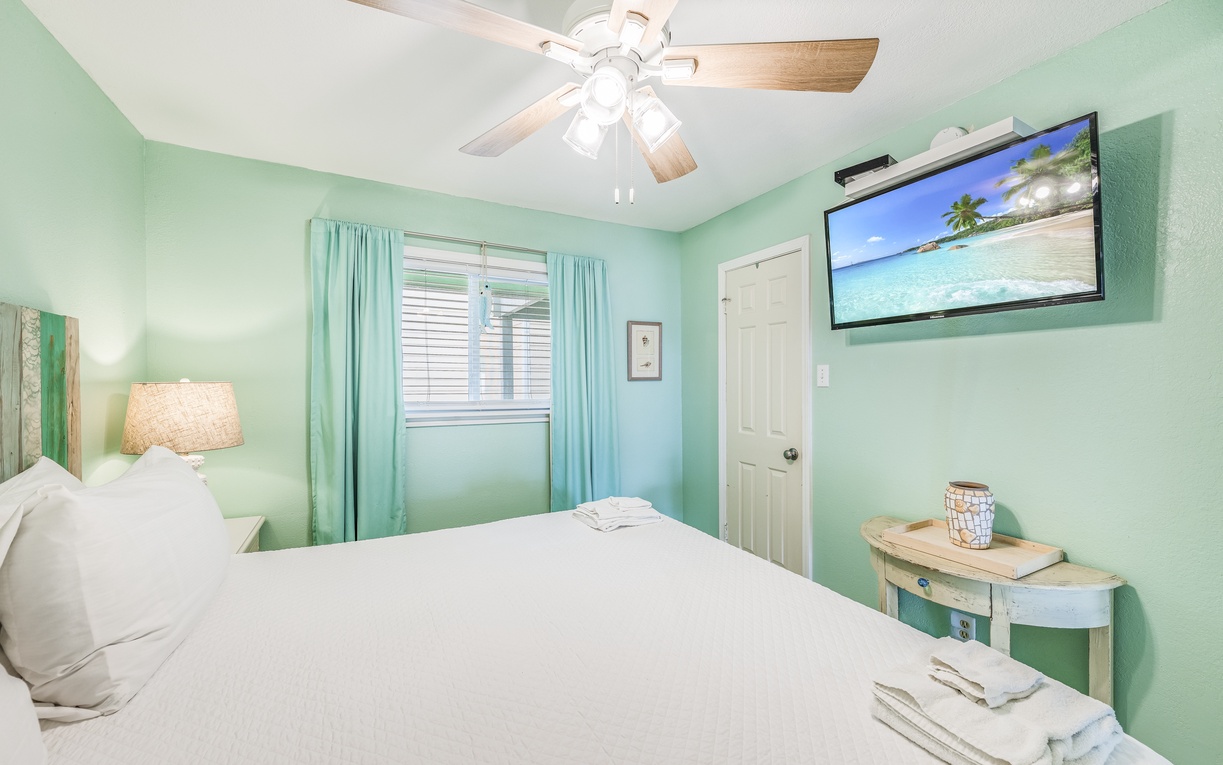 Drift off in your serene seafoam bedroom, where tropical breezes from the ceiling fan and beach scenes on TV create the perfect seaside sanctuary.