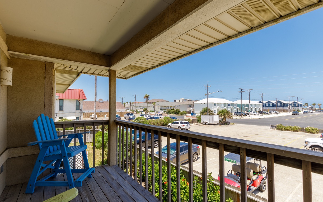 Relax in your bright blue Adirondack chair on this covered balcony, perfect for morning coffee or evening cocktails while watching the coastal community below.