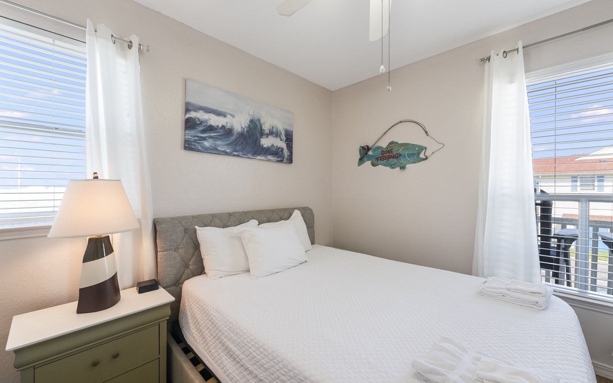 Rest peacefully in this bright bedroom with plush white linens and a charming mint dresser for your belongings.
