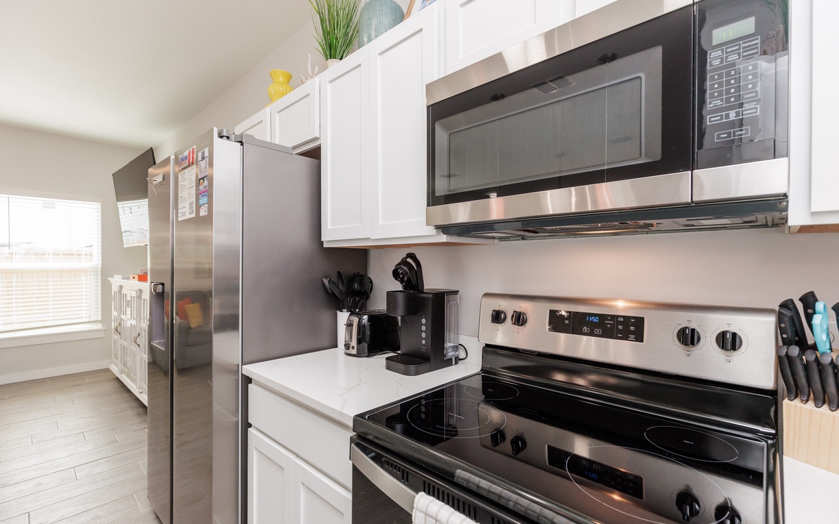 Your fully equipped kitchen features modern stainless steel appliances, crisp white cabinets, and everything you need to create delicious meals.