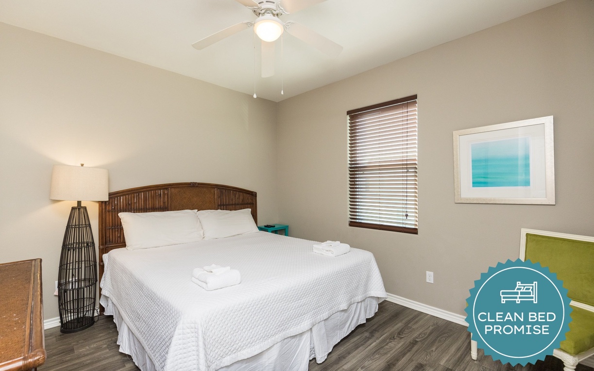 Unwind in your peaceful bedroom with crisp linens and gentle ceiling fan breeze creating the perfect sleeping sanctuary.