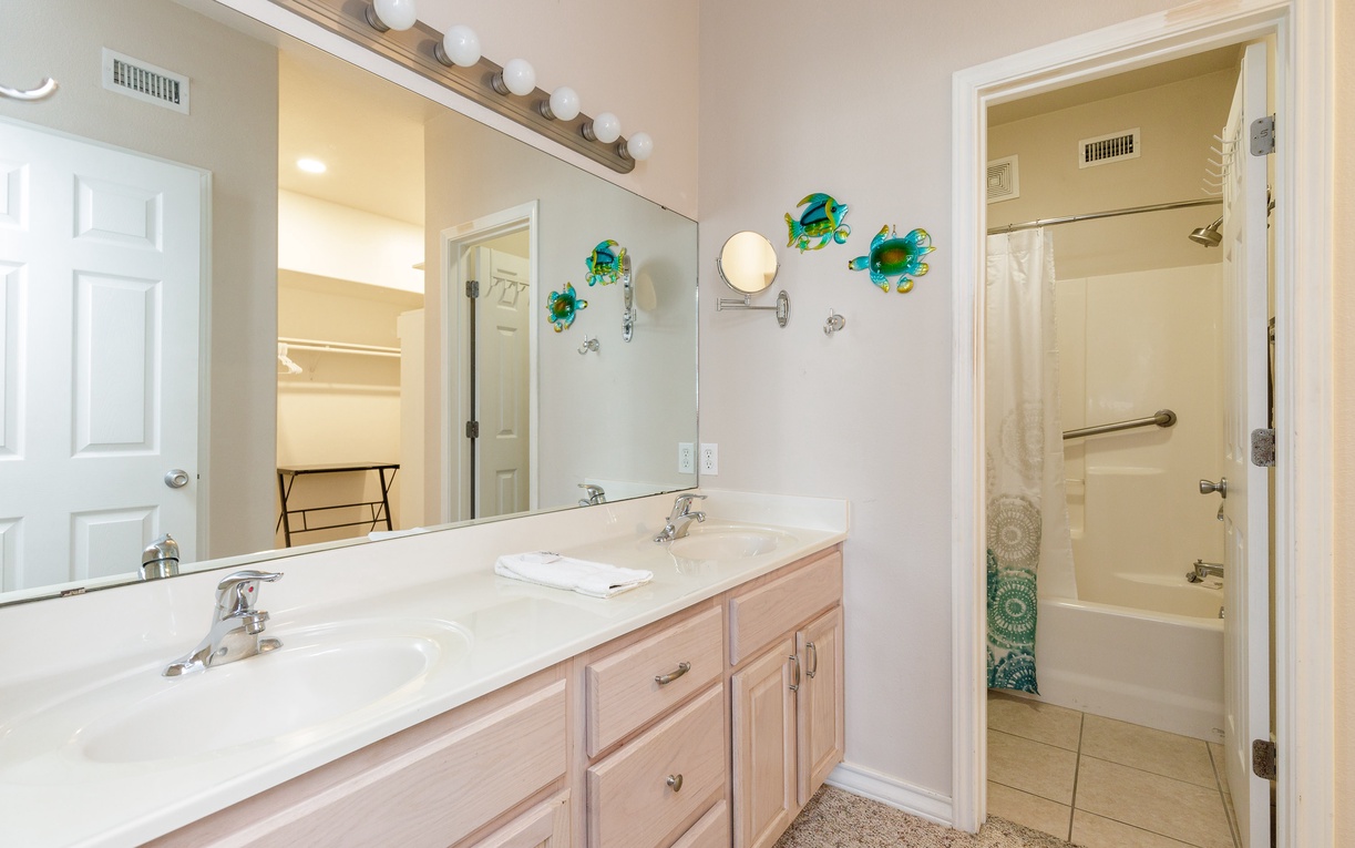 Your spacious bathroom features dual sinks with ample counter space, perfect vanity lighting, and a relaxing tub-shower combo for unwinding after beach days.