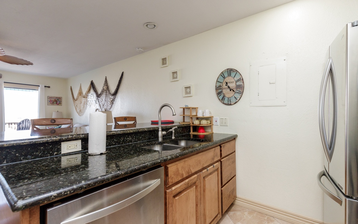 Your fully equipped kitchen features granite counters, stainless appliances, and charming coastal touches for memorable meal prep.