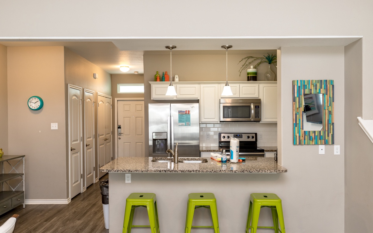 Your modern kitchen features granite countertops, stainless appliances, and a breakfast bar perfect for morning coffee or casual meals.