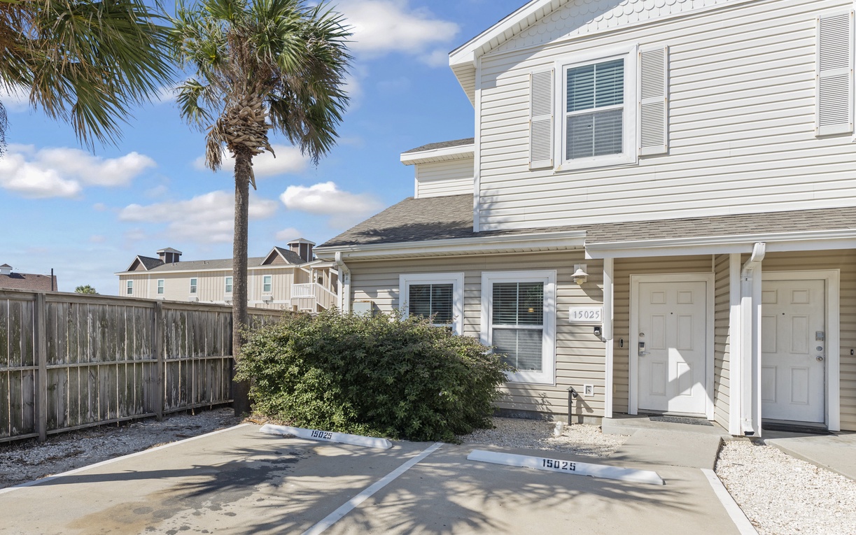 Charming coastal townhome with palm trees and dedicated parking, perfectly positioned for your beach getaway.