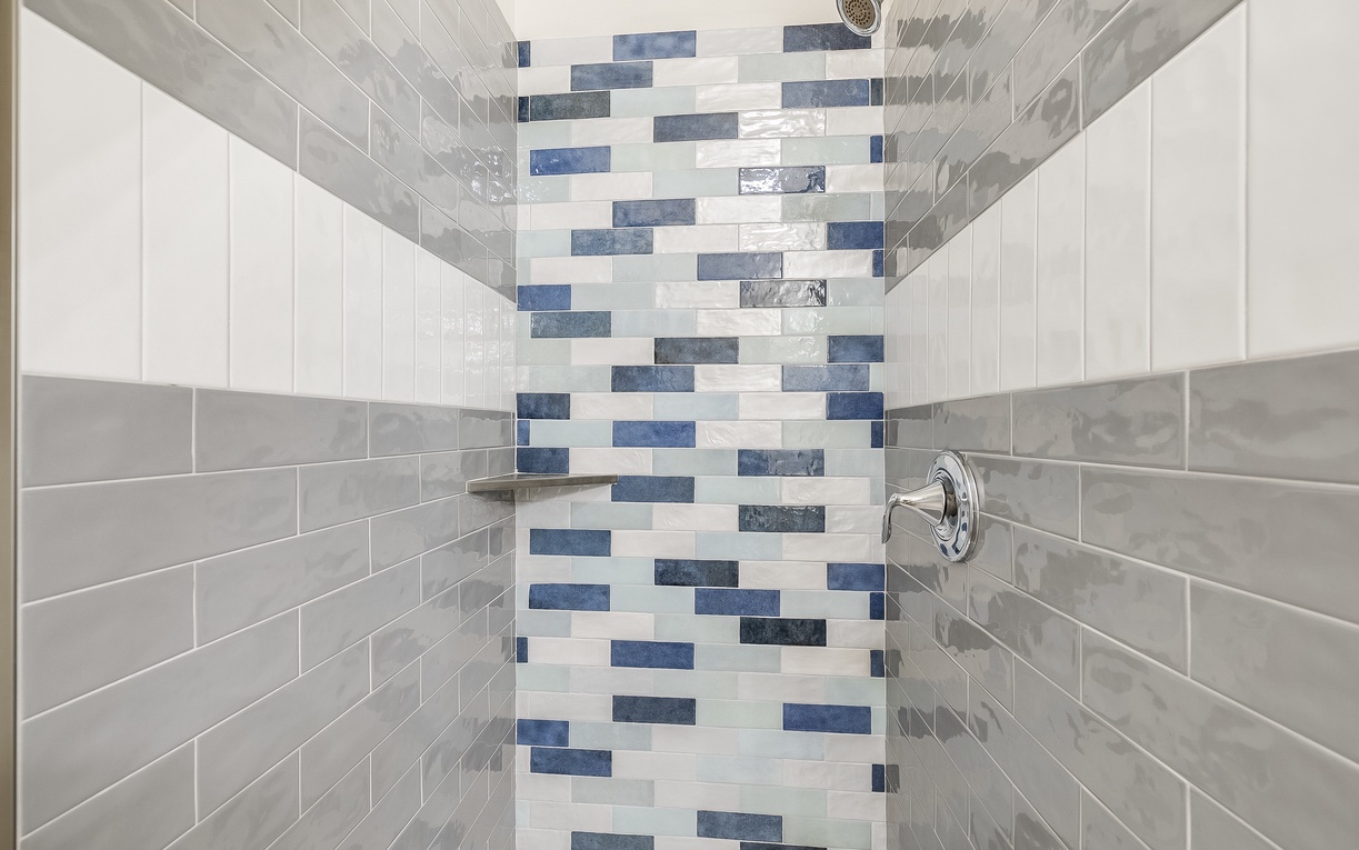 Step into your beautifully tiled shower featuring stunning mosaic accent walls and rainfall showerhead for the perfect relaxing retreat.